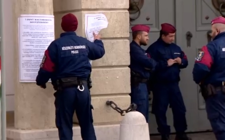Rendőr letépi a falragaszt kordonbontás a Karmelitánál
